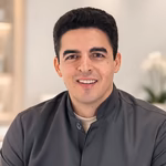 Dr. Lucas Santana Passos, ginecologista, sorrindo, de jaleco cinza-escuro